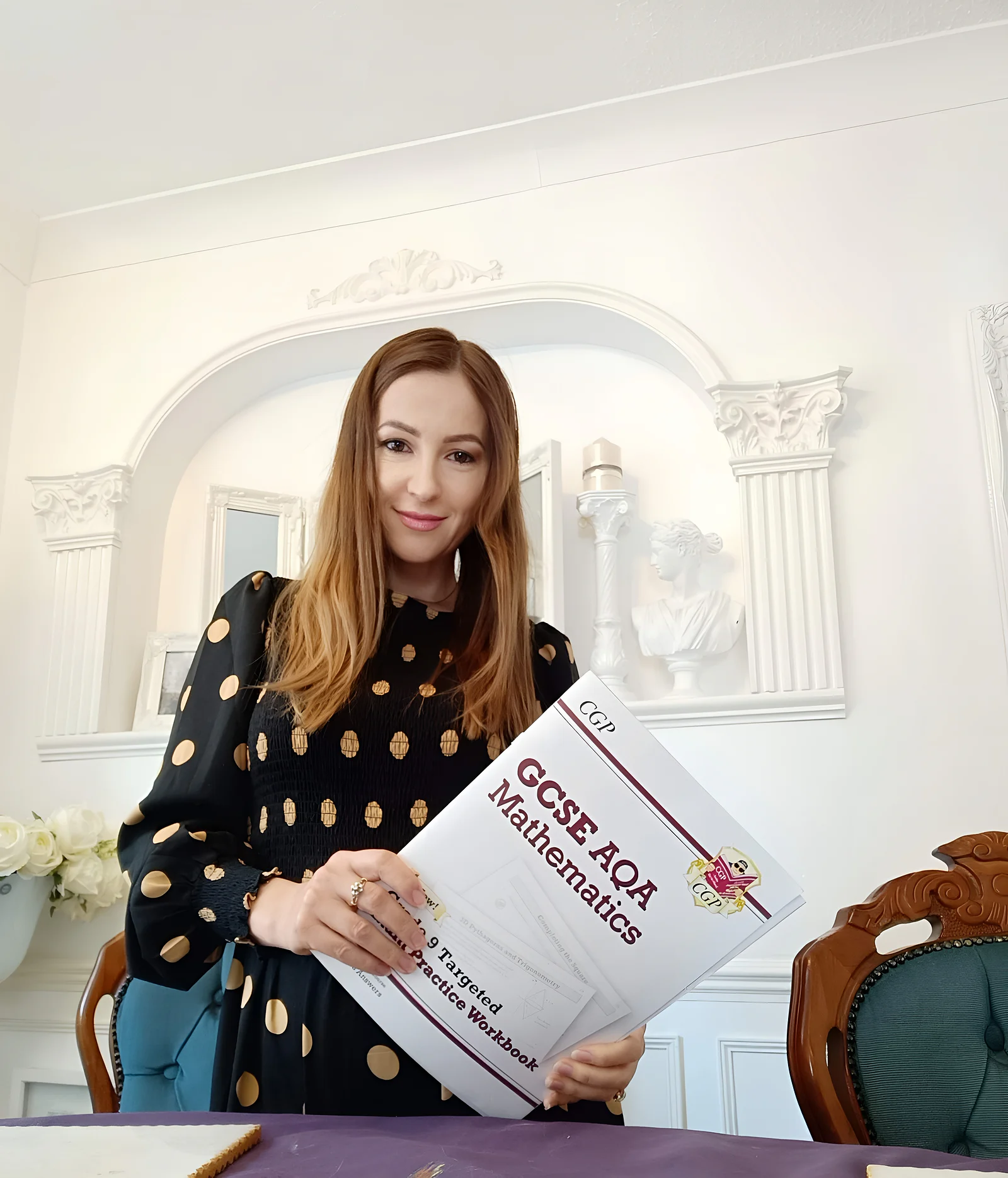 Natasha holding a GCSE AQA Mathematics workbook
